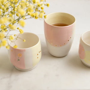 A fun, taller cup is useful for both hot or cold drinks displaying the colours of the rainbow with the added detail of 23K gold dots and one little flower of various designs.   As the details contain precious metal, 23K gold they do not microwave safe.